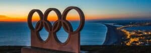 a view of a sunset over the ocean with a sculpture in the foreground.